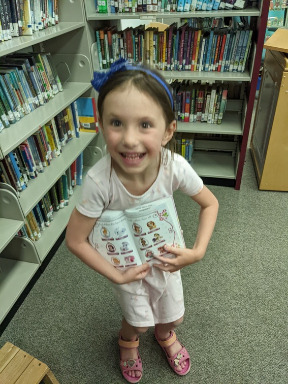 So Excited for a Book She Found at the School LIbrary