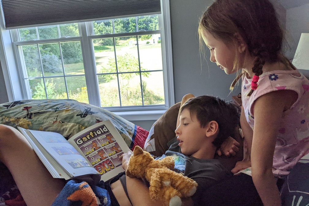 Reading Comics to His Sister